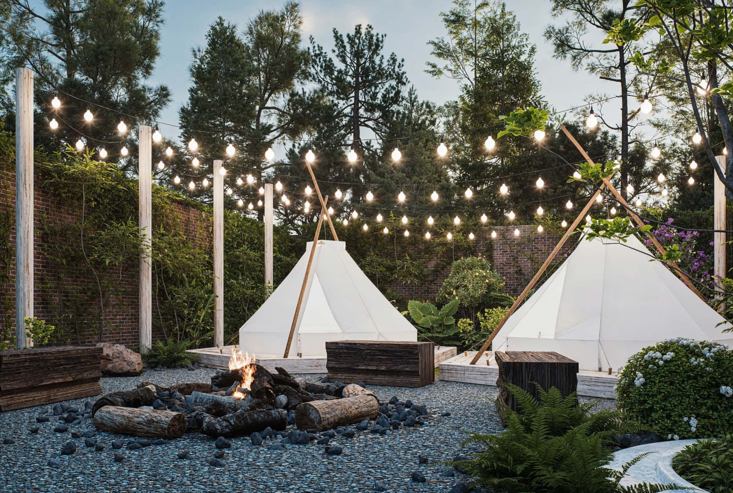 Khu lều glamping với dây đèn và lửa trại giữa vườn cây tại Cu Chi Downtown